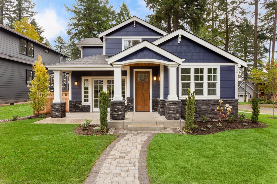 a house with a lawn in front of a brick building